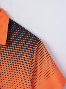 Close-up of men's orange polo shirt featuring black polka dot gradient print pattern