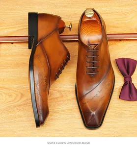 Dettaglio di scarpe Oxford in pelle marrone con incisione script e finitura sfumata artigianale