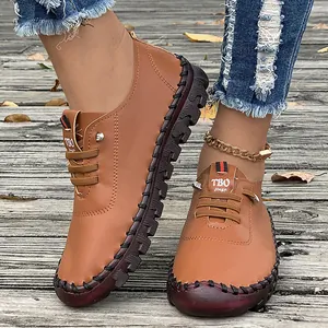 Close-up detail of handmade soft sole leather loafers for women shown on a wooden deck