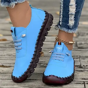 Close-up view of light blue women's casual flat shoes with decorative handmade stitching