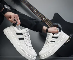 Close-up view of white leather men's platform sneakers featuring black diagonal stripe design