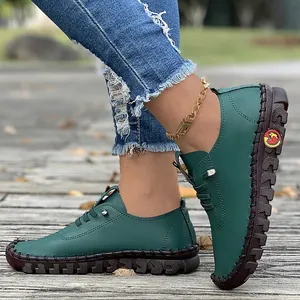 Close-up detail of dark green handmade casual flats with durable soft rubber soles.
