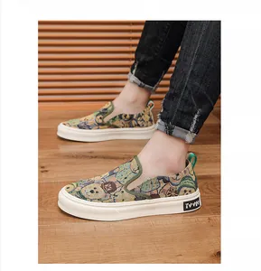 Close-up of men's canvas slip-on shoes with a detailed cartoon bear tapestry pattern.