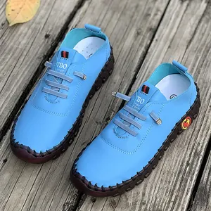 Detailed top-down view of light blue handmade soft sole loafers with grey elastic laces