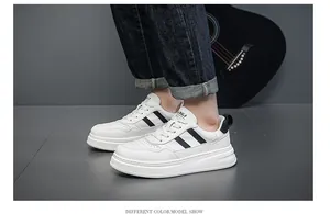 Detail view of men's white leather sneakers with black stripes and thick soles