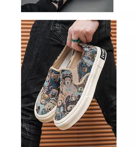 Close-up of men's slip-on canvas shoes featuring vintage cartoon bear tapestry pattern.