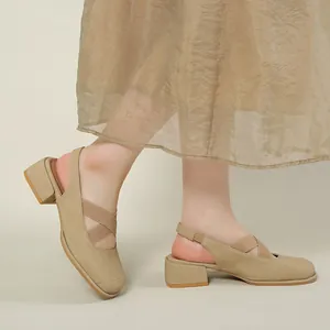 Beige square-toe cross strap sandals with low chunky heel shown on model in vintage style