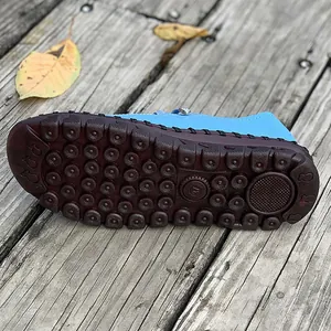 Close-up detail of non-slip brown rubber sole on blue comfortable flat walking shoes for women