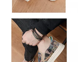 Detail view of men's slip-on canvas shoes with cute cartoon bear pattern on wood floor