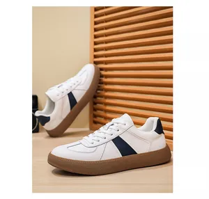 Gedetailleerd beeld van witte lederen De-Xun sneakers met blauwe strepen en gomzool