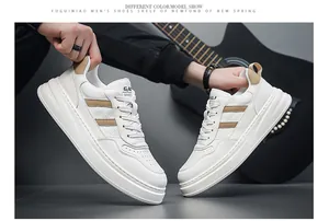 Detail view of stylish men's white leather sneakers featuring thick soles and tan stripes