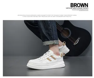 Side view detail of white men's leather sneakers with stylish brown stripes and thick sole.