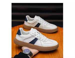 Detailopname van leren herensneakers met marineblauwe streep en rubberen zool.