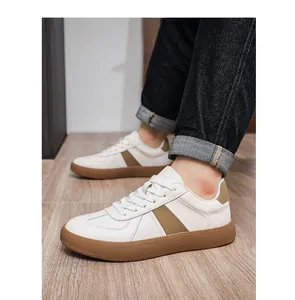 Detail van heren GAT-sneakers van wit leer met rubberen zool en stijlvolle bruine accenten