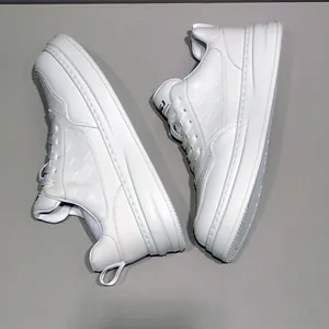 Dettaglio di sneaker da uomo in pelle bianca con suola spessa e lato strutturato