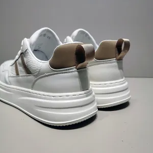 Detailed rear view of white leather men's sneakers with thick soles and khaki accents.