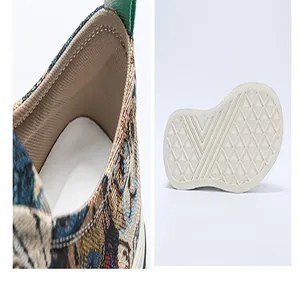 Detail of men's canvas slip-on shoes with cartoon bear pattern and textured rubber sole