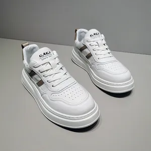 Detail view of men's white leather sneakers with thick soles and tan stripe accents