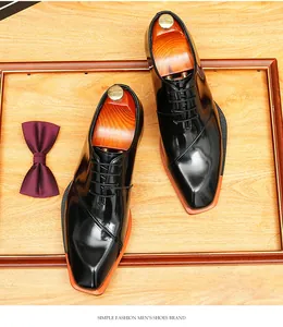 Vista superior de zapatos oxford de charol negro para hombre en bandeja madera