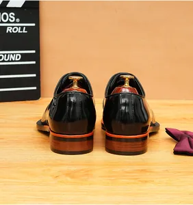 Vista trasera de zapatos de hombre en charol negro con tacones de madera decorados