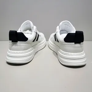 Rear view of white leather sneakers with black stripes and thick platform soles