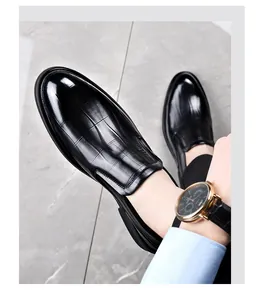 Close-up of elegant black leather dress shoes with embossed pattern and sharp pointed toe