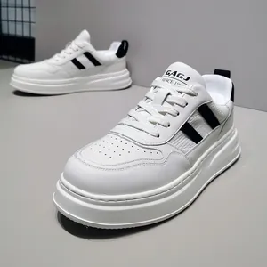 Close-up of white leather sneakers featuring black diagonal stripes and a thick sole.