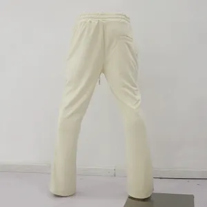 Back view of cream flared drawstring trousers for men with micro-flare leg