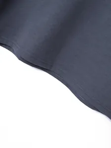 Detailed macro view showing the precise double-needle stitching on a dark grey polo shirt hem