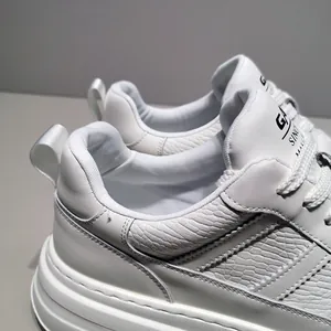 Close-up of white leather men's sneakers showing textured pattern and thick sole design