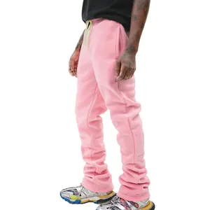 Close-up of men's pink flared drawstring sweatpants with slim fit and stacked hem.
