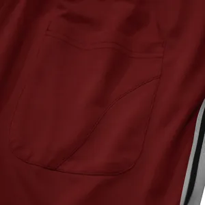 Detailopname van een bordeauxrode herensweatpants met een achterzak en zijstrepen.