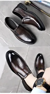 Macro detail of men's brown leather slip-on shoes featuring crocodile embossing
