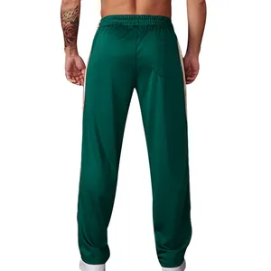 Achteraanzicht van losse groene sportbroek voor heren met zijstrepen en achterzak