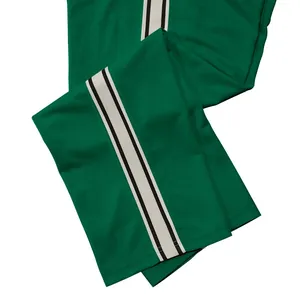 Detail van groene herensportbroek met een stijlvolle witte zijstreep en rechte pijp