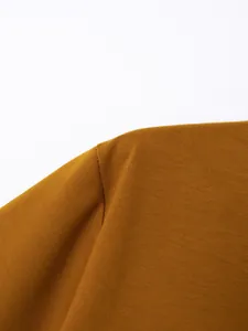Close-up of shoulder stitching on brown cotton men's polo shirt showing fabric texture.
