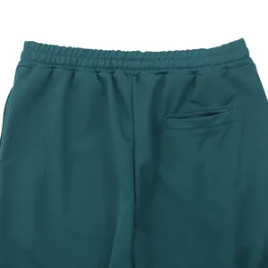 Close-up detail of the elastic waistband and back pocket on dark teal men's pants