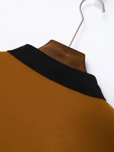 Close-up detail of the black collar and brown cotton fabric on a men's polo shirt