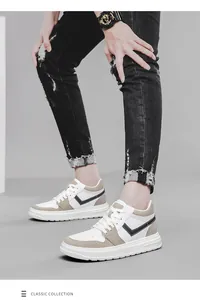 Close-up of stylish white and beige sneakers worn with black distressed jeans