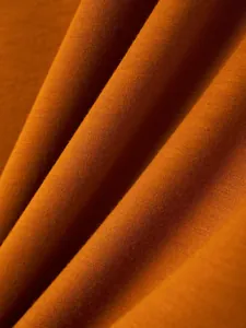 Close-up macro detail of burnt orange knitted fabric showing soft texture and fine weave