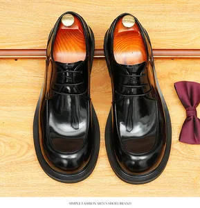 Top-down view of black leather Derby shoes with round toe and wooden shoe trees