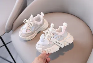 Detailansicht weißer Mesh-Chunky-Sneaker für Mädchen mit Herzanhänger auf grauem Sessel