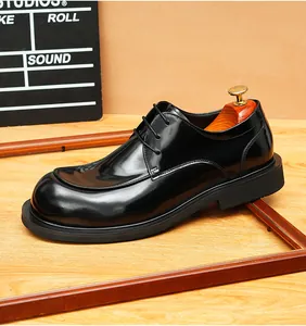 Close-up of polished black leather derby shoe with round toe and thick sole