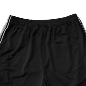 Detailopname van een zwarte heren joggingbroek met elastische tailleband en zijstrepen