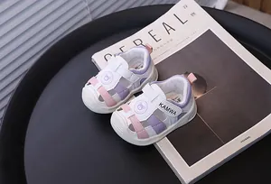 Primer plano de sandalias blancas para bebé con patrón de oso y cierre de velcro KAMWA