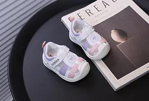 Detalle de sandalias para niños pequeños en violeta y rosa con logo de oso y KAMWA