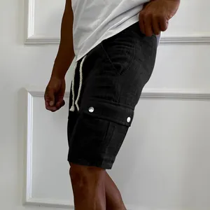 Detailed side view of black cargo shorts with drawstring and buttoned pockets