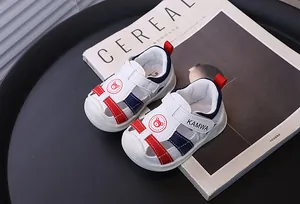 Primer plano de sandalias blancas para bebés con punta cerrada y rayas.