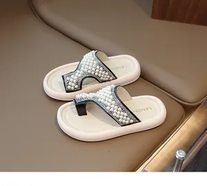 Detalle de sandalias de dedo con perlas y pedrería para niñas