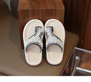 Primer plano de sandalias con perlas para niña con tiras adornadas con pedrería
